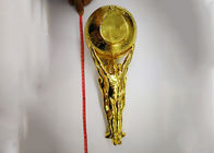 De glanzende Goud Geplateerde Kop van de Douanetrofee met het Standbeeld die het Balontwerp houden